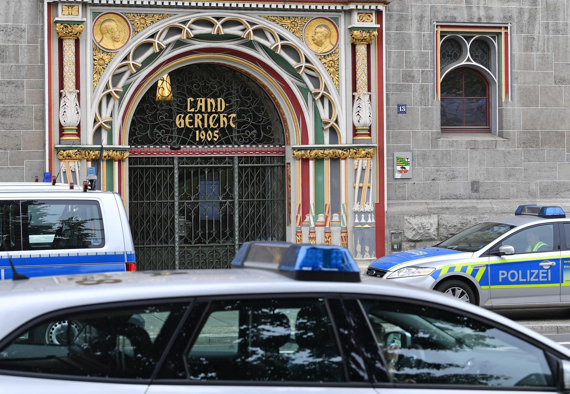 Polizeifahrzeuge stehen vor dem Landgericht in Halle