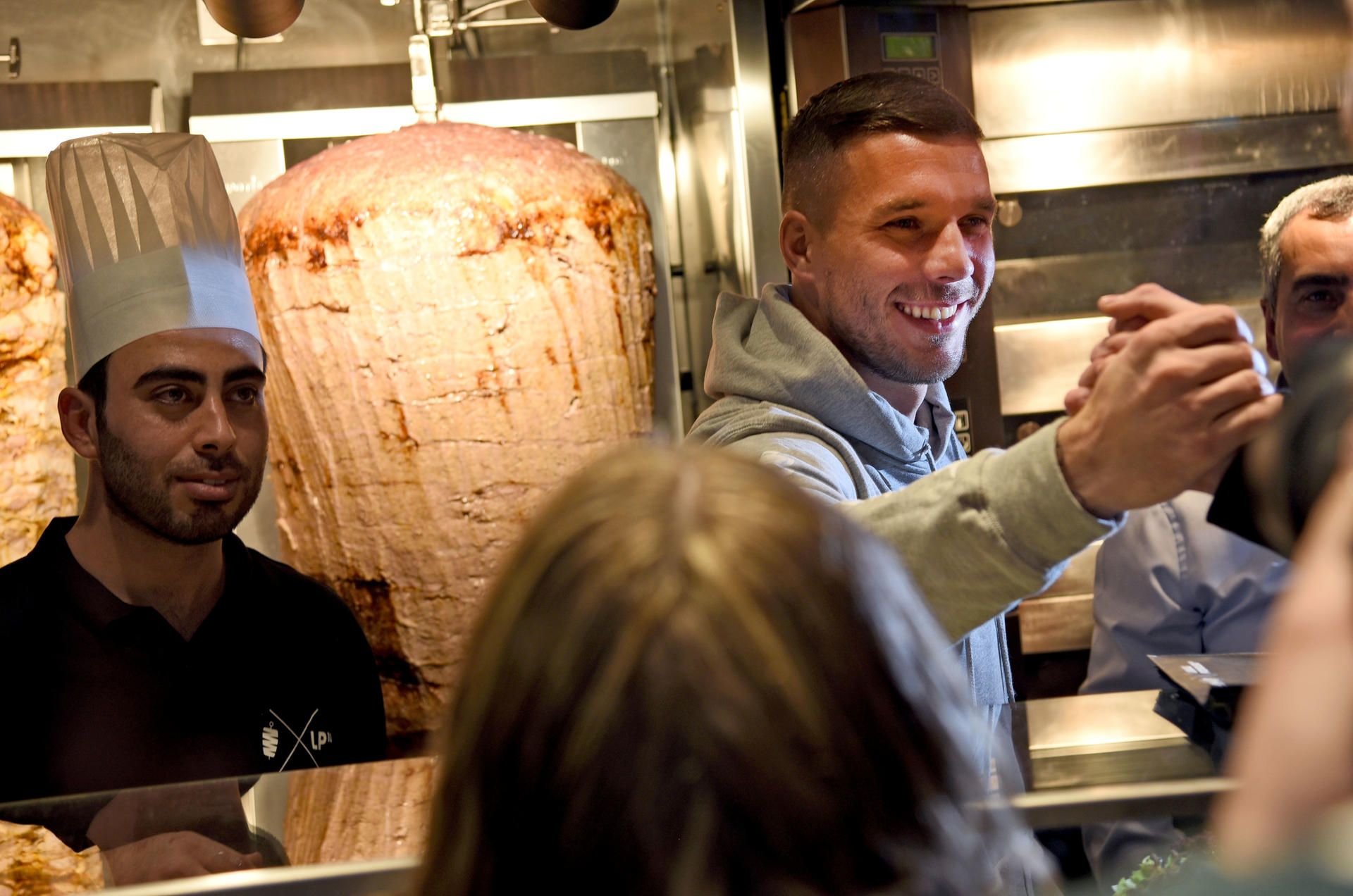 Lukas Podolski begrüßt bei der Eröffnung eines Döner-Ladens die Kunden.
