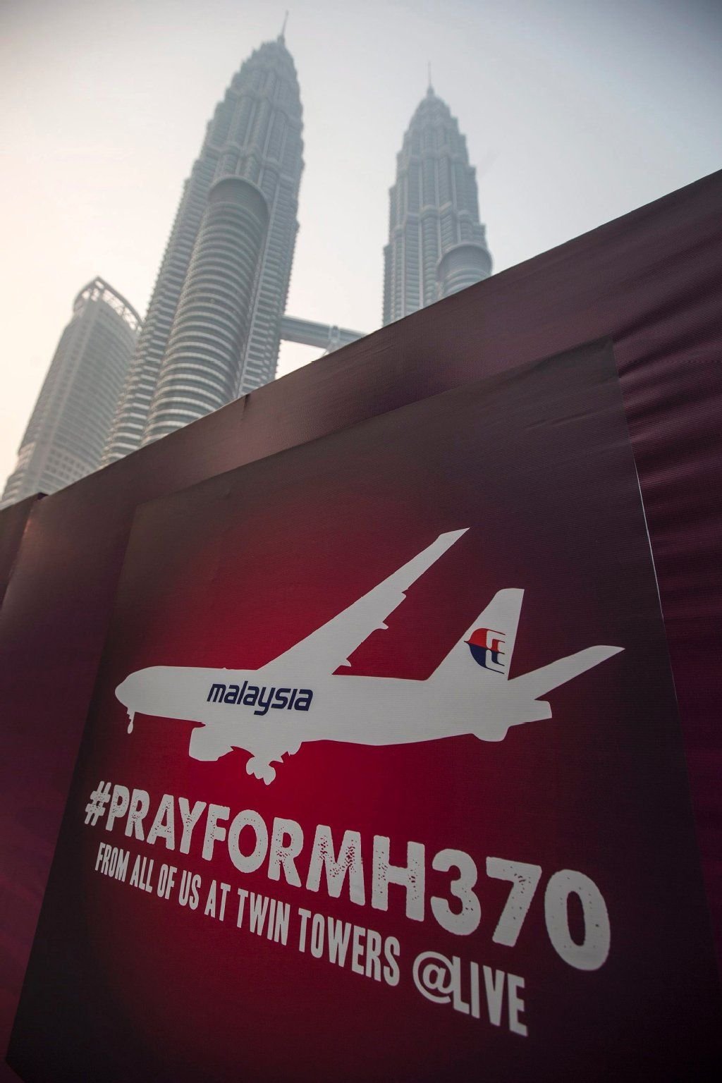 Ein Schild mit der Aufschrift „Pray for MH370" vor dem Petronas-Tower in Kuala Lumpur