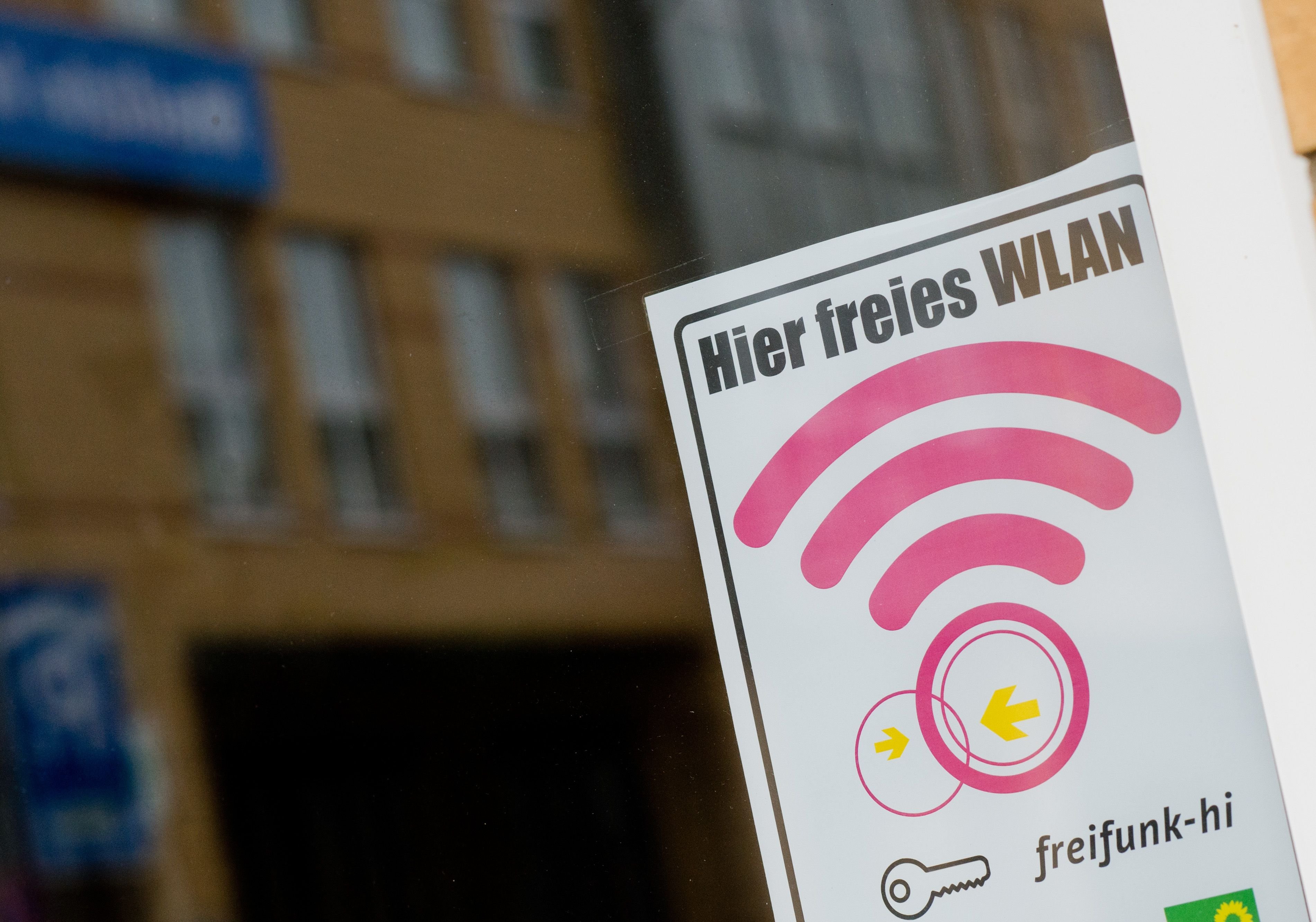 Ein Schild "Hier freies WLAN" weist auf einen Hotspot eines kostenlosen Netzwerkes hin.