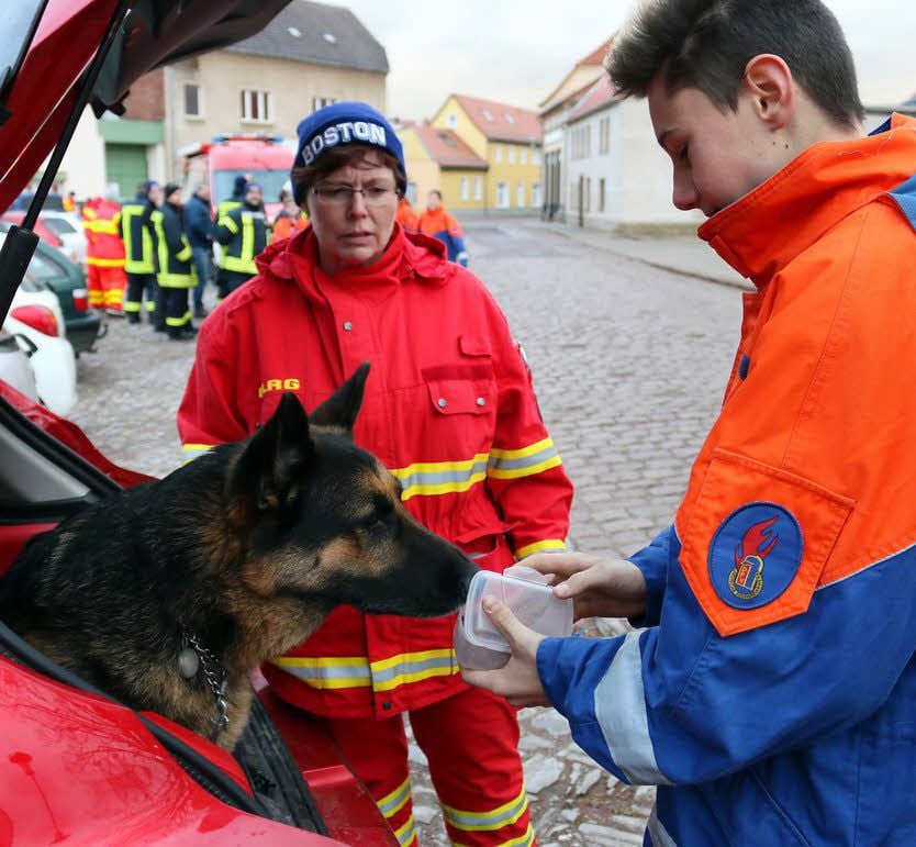 Als Belohnung für die erfolgreiche Suche bekommt Rambo von Piere Böwe und Hundeführerin Simone Mühlbach ein Leckerli.