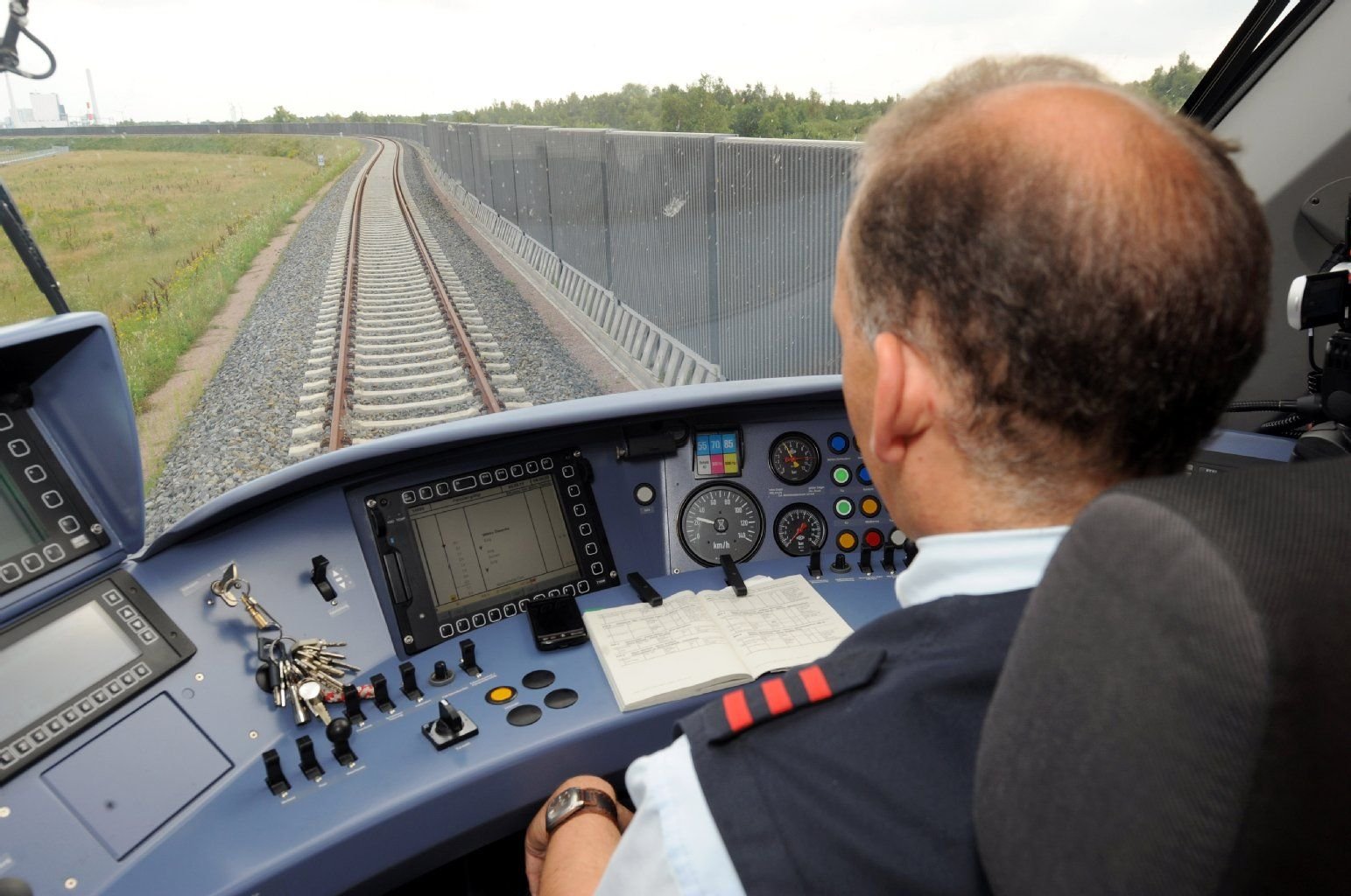 Ein Lokführer der Bahn sitzt im Führerstand eines Zuges.