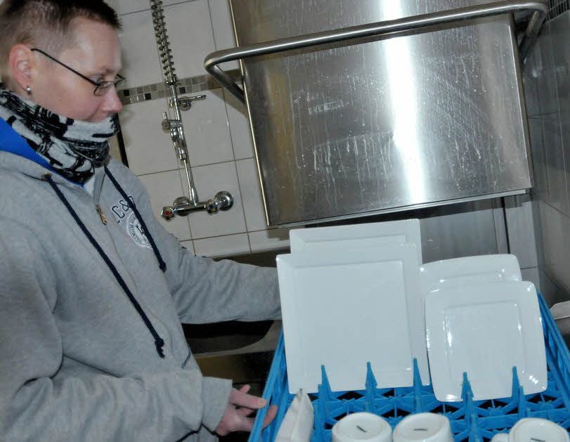 Sabine Walther, Mitarbeiterin der Tiergartenschenke, holt das Geschirr aus der Spülmaschine.