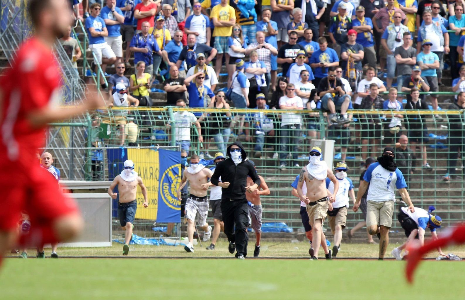 Anhänger des Fußball-Süd-Oberligisten 1. FC Lok Leipzig laufen während des Spiels in der 75. Minute auf den Platz.