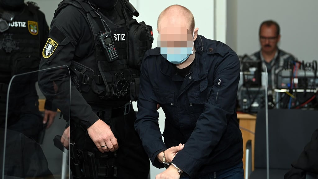 Der Angeklagte mit seinen Bewachern.