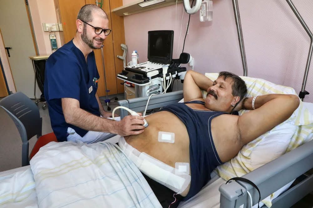 Oberarzt Fritz Woehe untersucht Uwe Rückriem ein paar Tage nach der schweren Operation.