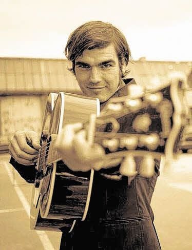 Martin Goldenbaum im Porträt mit einer Gitarre.