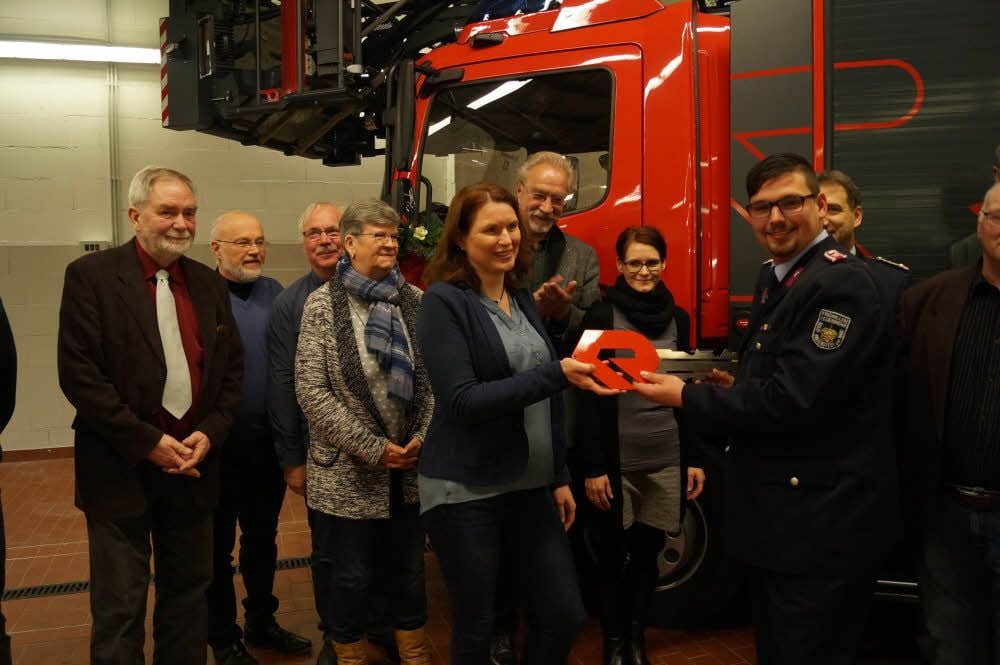 Annett Ograbek übergibt den symbolischen Zündschlüssel für das neue Hubrettungsfahrzeug an die Feuerwehr in Ballenstedt.