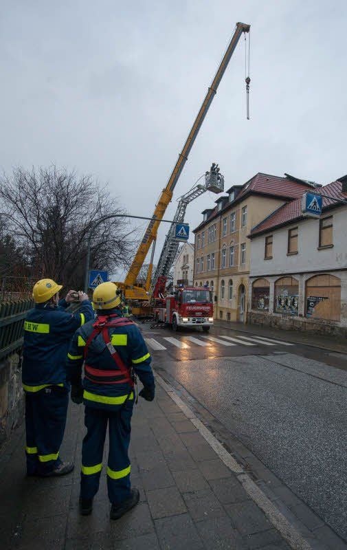 Mit einem Kran werden die losen Teile des Daches heruntergenommen.