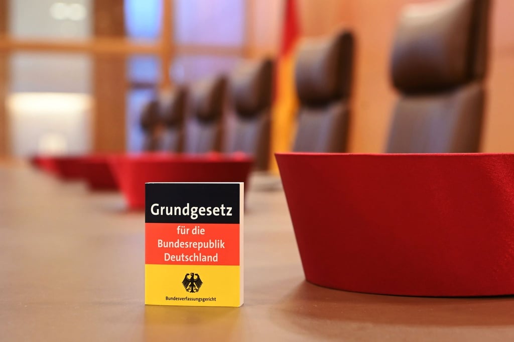 Auf der Richterbank im Sitzungssaal liegen Barette der Bundesverfassungsrichter des ersten Senats.