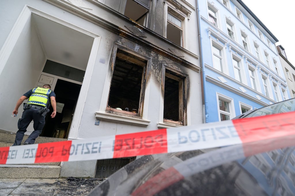 Ein Polizist betritt den Hauseingang neben der Brandwohnung.