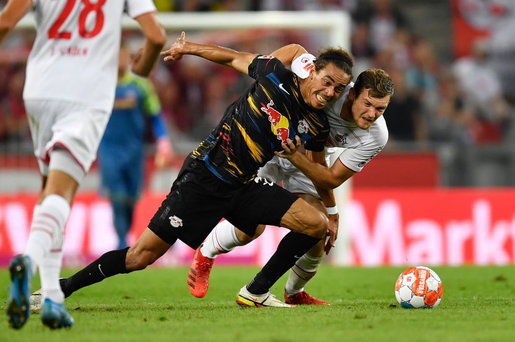 Leipzigs Yussuf Poulsen (l) und Kölns Luca Kilian kämpfen um den Ball.