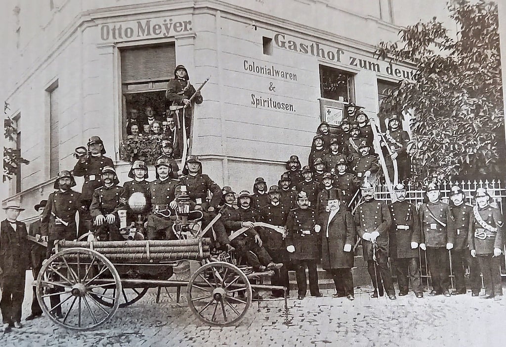 Diese Aufnahme von 33 Kameraden der Freiwilligen Feuerwehr Pretzien um ihren Handlöschwagen stammt vermutlich aus dem Jahr 1906 und wurde vor dem Gasthof Zum deutschen Kaiser (heute Parkhotel), dem Gründungslokal der Wehr, aufgenommen.