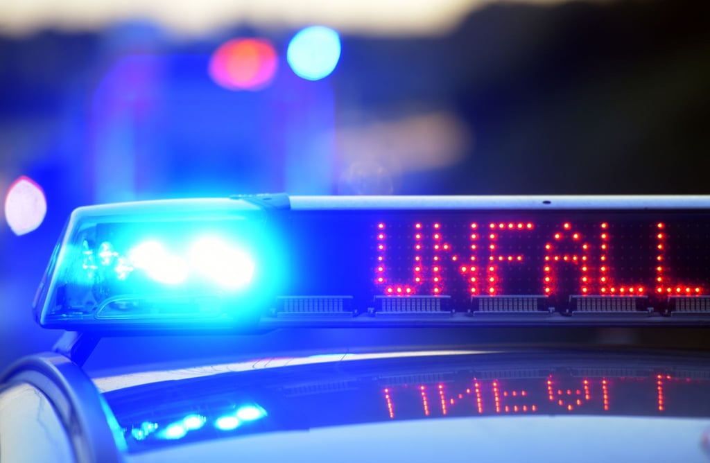 Auf einem Polizeifahrzeug warnt eine Leuchtschrift vor einer Unfallstelle.