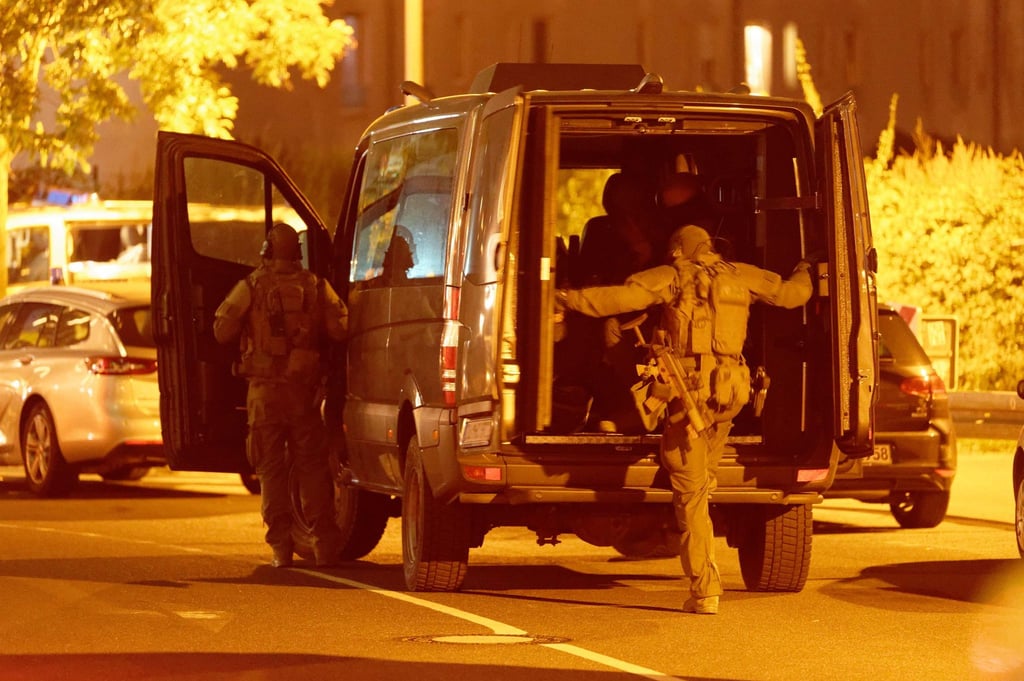 Einsatzkräfte steigen vor einem Düsseldorfer Hotel in ihr Fahrzeug.