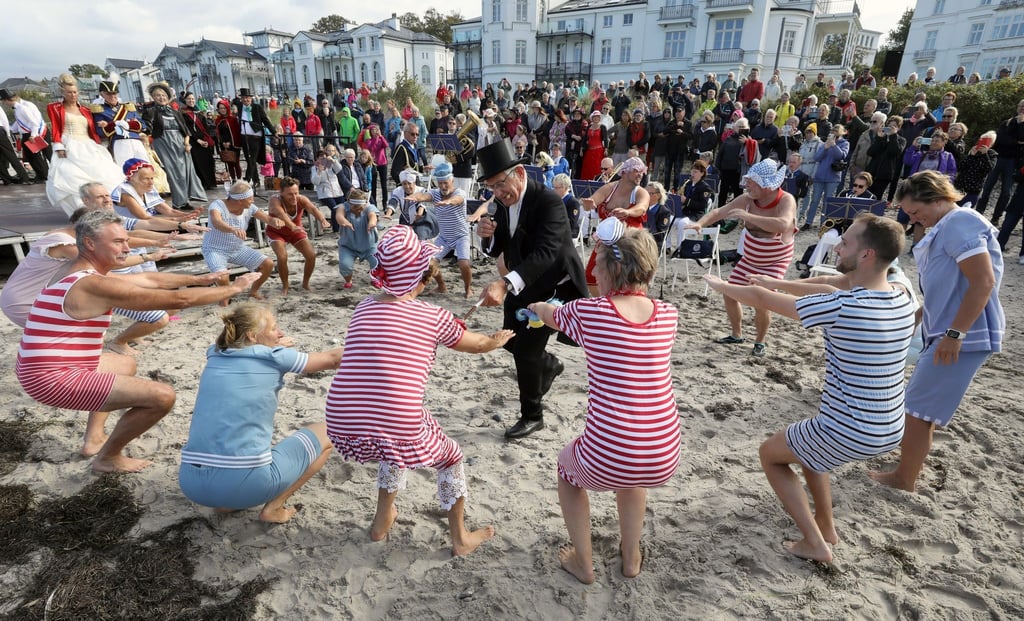 Teilnehmer in historischer Bademode bereiten sich auf das „Abbaden“ in der Ostsee vor.