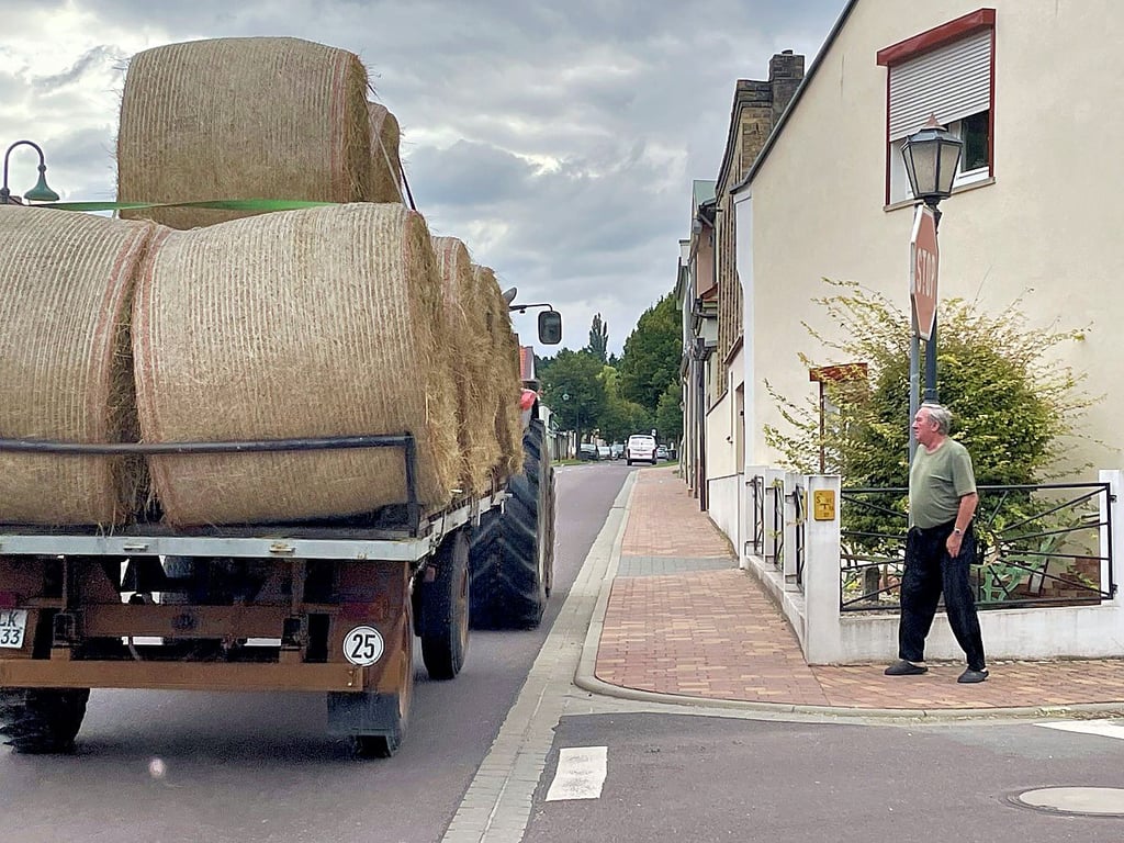 Jürgen Priese schaut zu, wie ein Traktor samt Ladung die Ascherslebener Straße befährt ? nah am Fußweg.