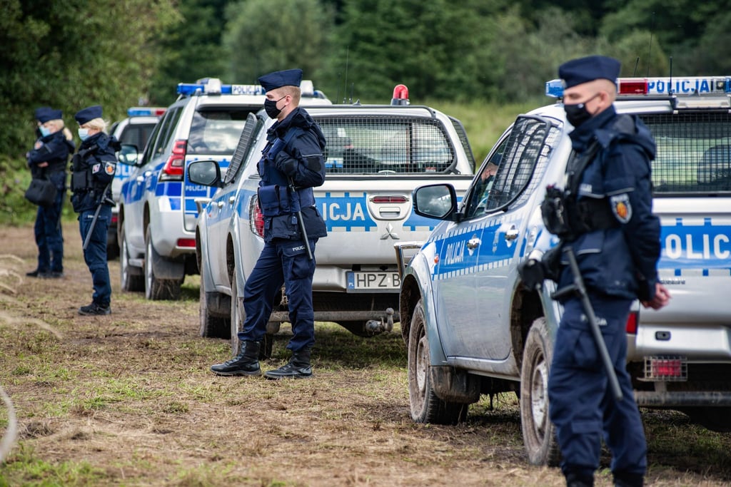 Polizeibeamte stehen an der polnisch-belarussischen Grenze.