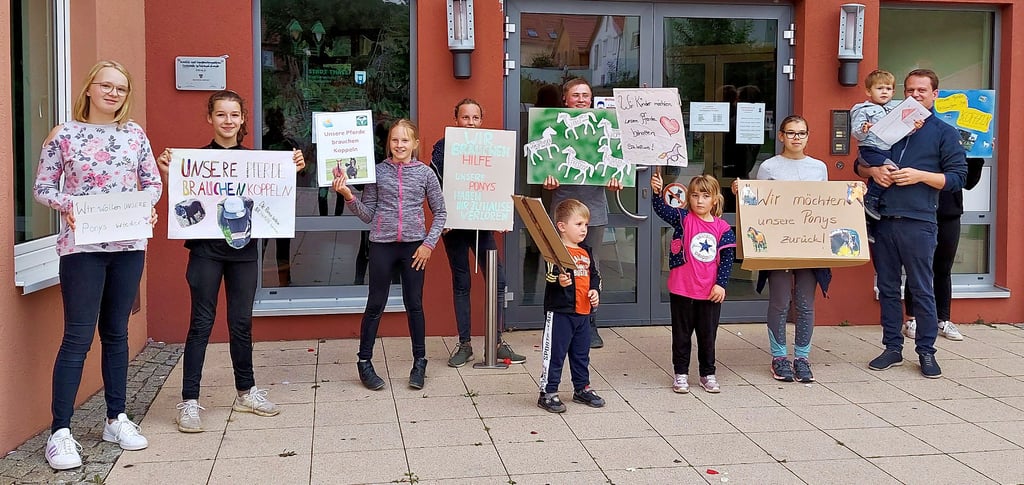 Mit selbst gebastelten Pappschildern verleihen die Kinder und Jugendlichen des Reitvereins ihrem Anliegen vor dem Rathaus in Thale Nachdruck.