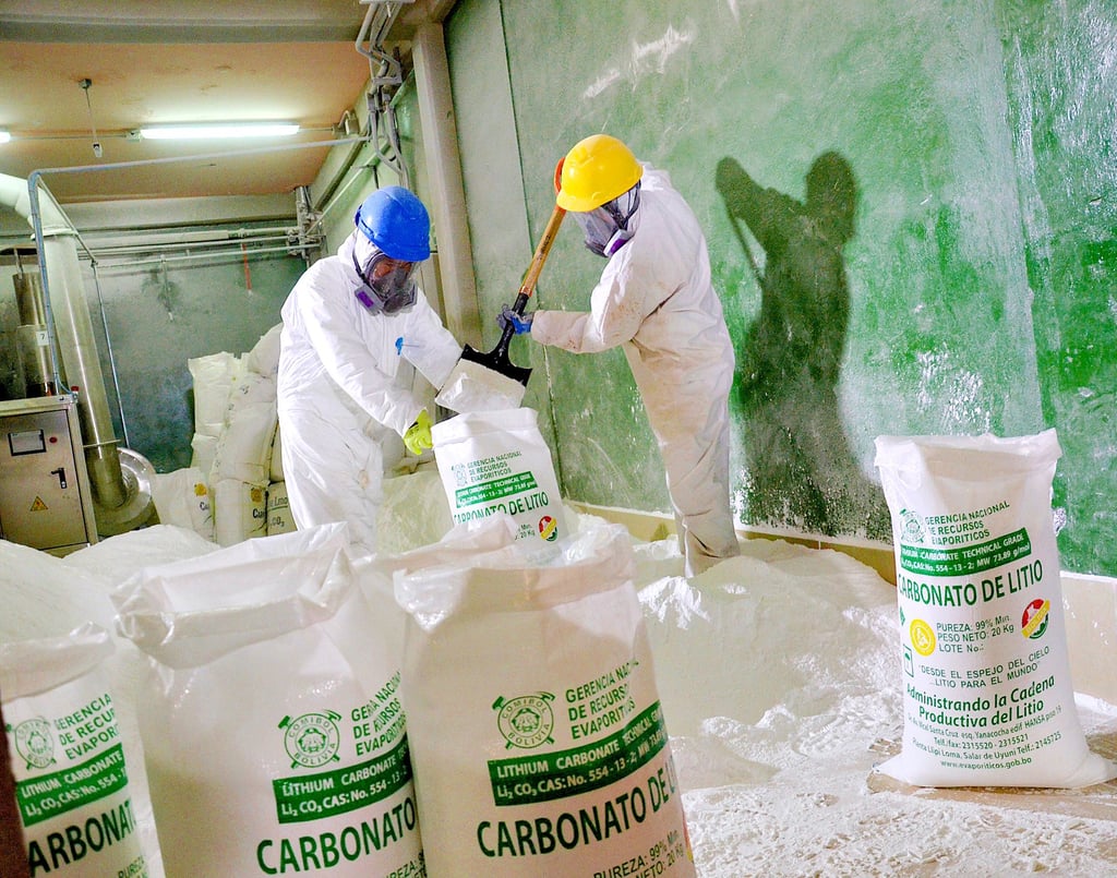 Arbeiter füllen in einer Pilotanlage am Salzsee von Uyuni in Bolivien Lithiumkarbonat in Säcke ein.