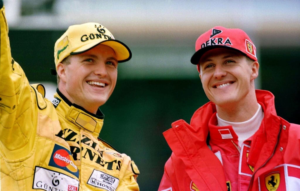 Die Brüder Michael Schumacher (r, Ferrari) und Ralf Schumacher (Jordan) winken nach dem Großen Preis von Deutschland auf dem Hockenheimring den Zuschauern zu.