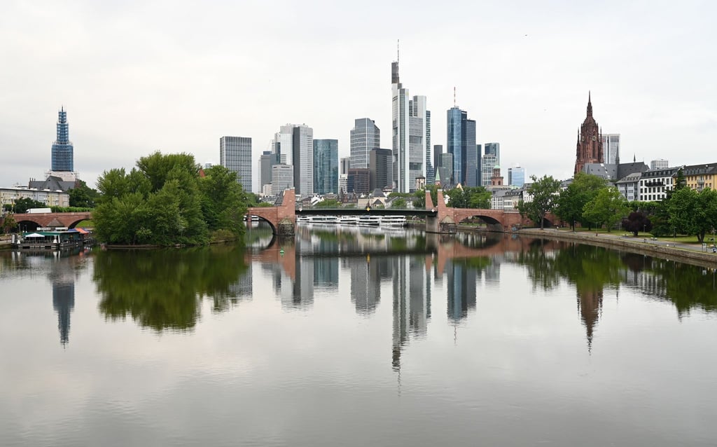 Die Frankfurter Skyline mit ihren markanten Bankentürmen spiegelt sich im Wasser.