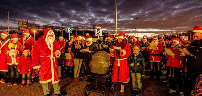 Knapp 100 Weihnachtsmänner und -frauen sangen.