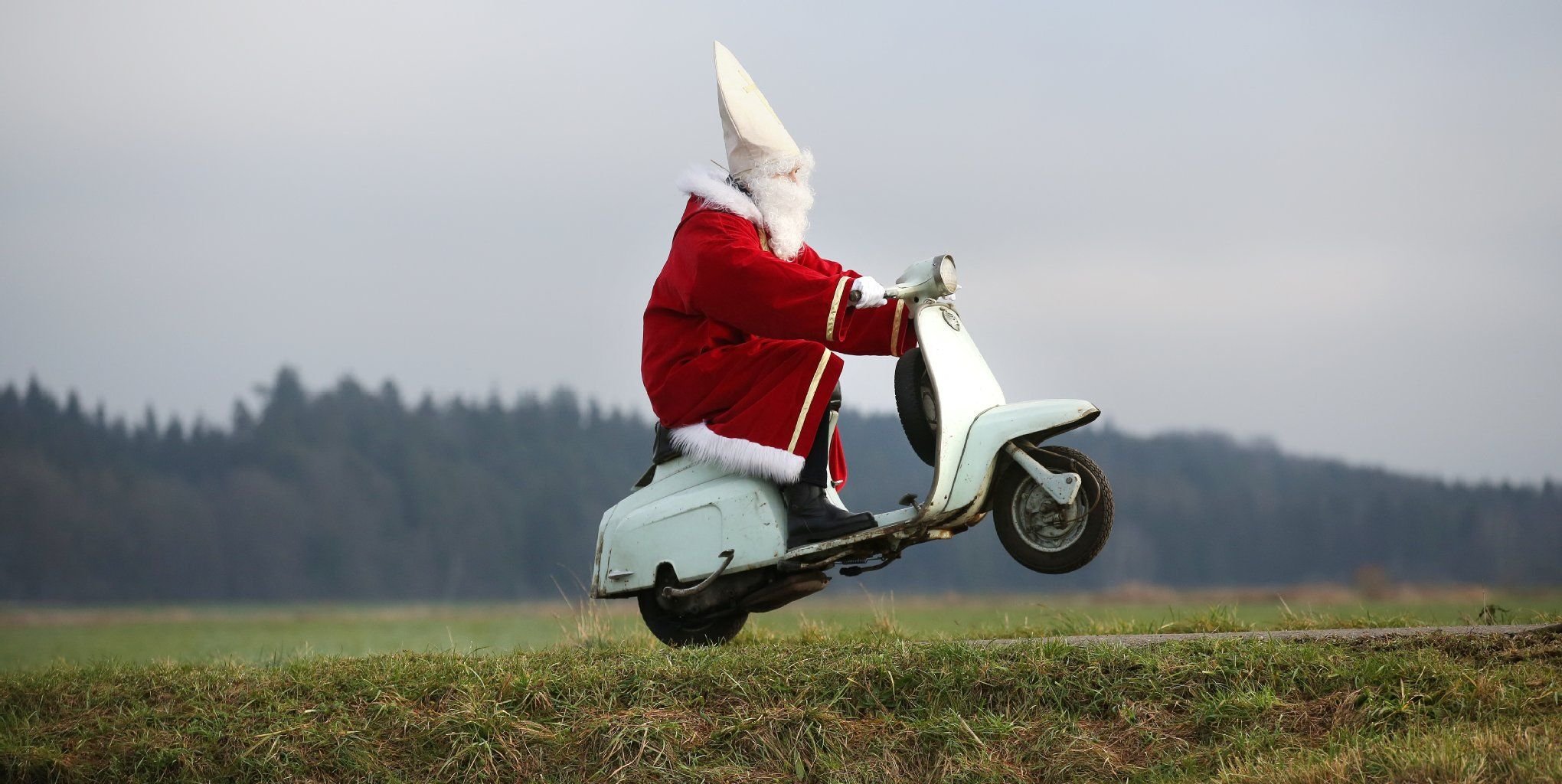 Ein als Nikolaus verkleideter Mann auf einem Roller