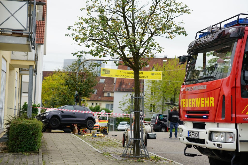 Einsatzkräfte sperren einen Bürgersteig nach einem Autounfall in Altbach.