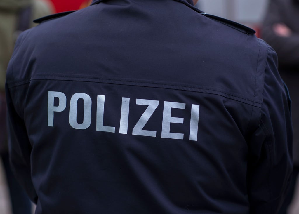 „Polizei“ steht auf der Uniform eines Polizisten.
