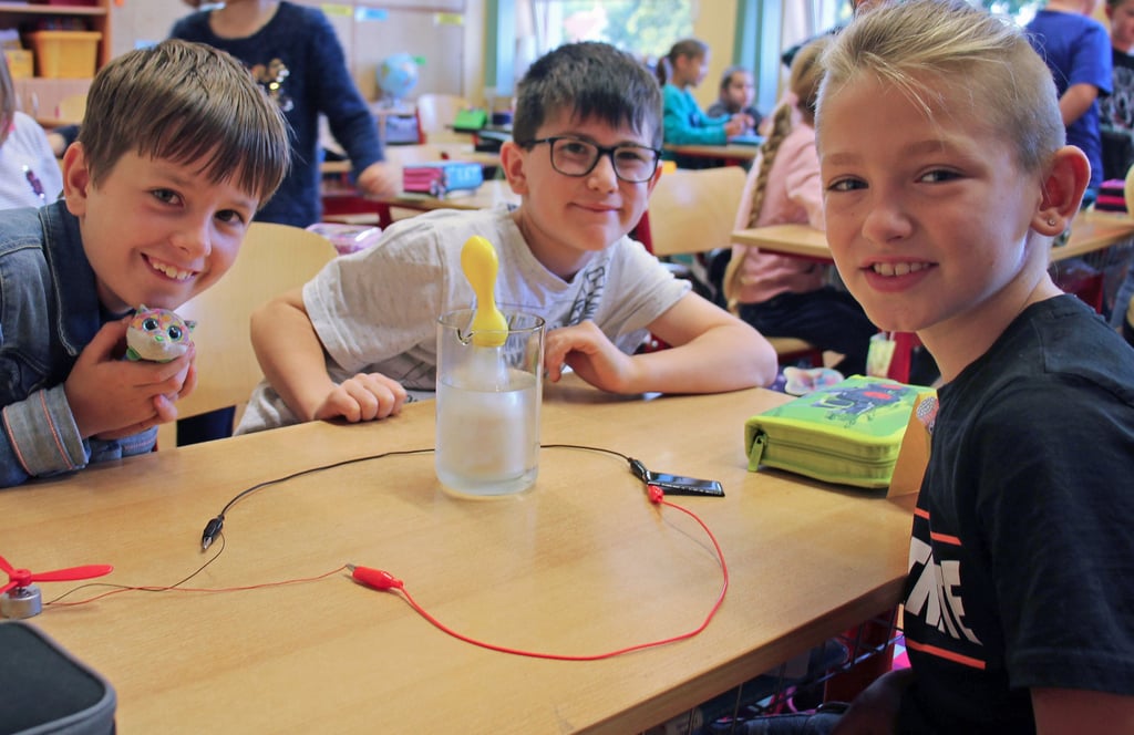 Adam (von links), Felix und Til haben eine Mini-Solaranlage zusammengebaut. Auch der Ballon über der Hefe füllt sich bereits mit Gas.