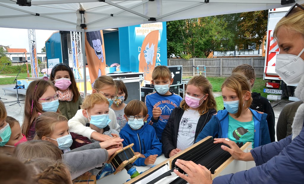 Carole Martiné vom Kinderchorland zeigt den Kindern anhand einer Simulation, wie die Stimmbänder im Körper funktionieren und von welchem Organ sie angetrieben werden.