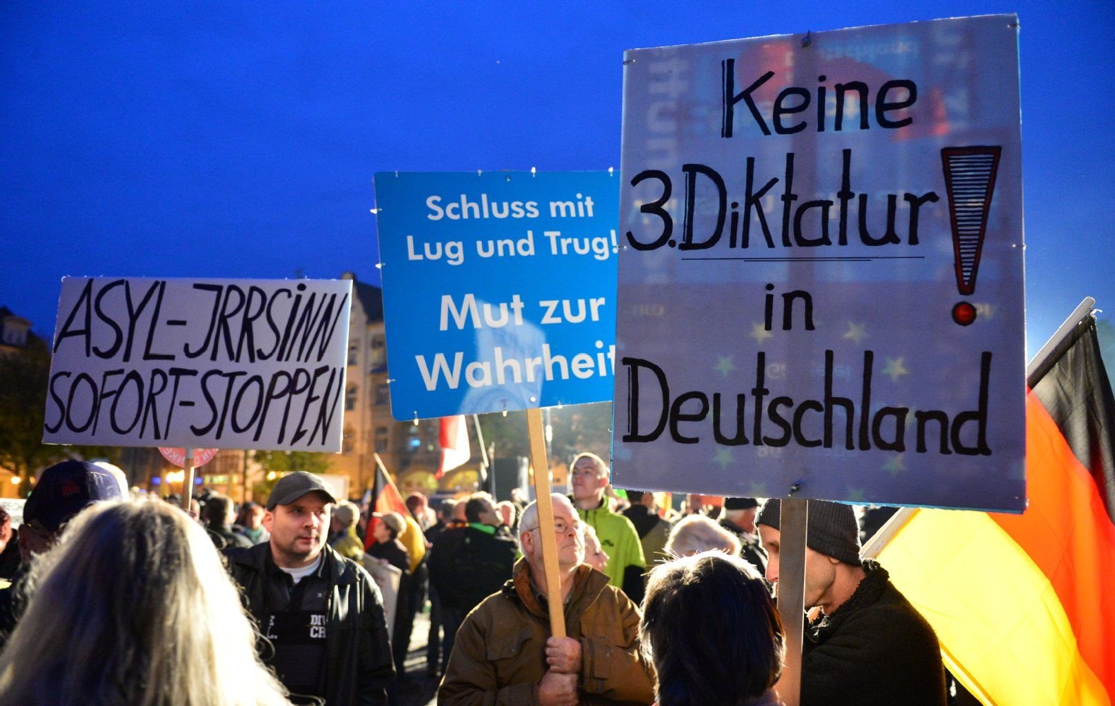 Teilnehmer einer Kundgebung der «Alternative für Deutschland» (AfD) schwenken in Erfurt Plakate und Transparente u.a. mit der Aufschrift «Asyl-Irrsinn sofort stoppen».