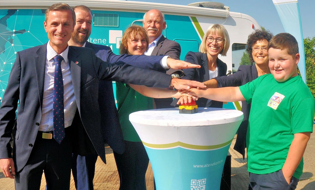 Großer Bahnhof in Klein Oschersleben: Oschersleben-Bürgermeister Benjamin Kanngießer, Daniel Knohr von ateneKOM, Lara aus der Klasse 9a, Holger Haupt von der Stabsstelle Breitband, Schulleiterin Silke Heick, Petra Naumann vom Dezernat 3 des Landratsamtes und Drittklässler Ben drücken gemeinsam den symbolischen roten Knopf. Kleines Bild: Die Lampe an der FritzBox im Serverkasten der Börde-Schule leuchtet schon. Heute kommt der Techniker und sorgt für die Anbindung ans Haus-Netz.