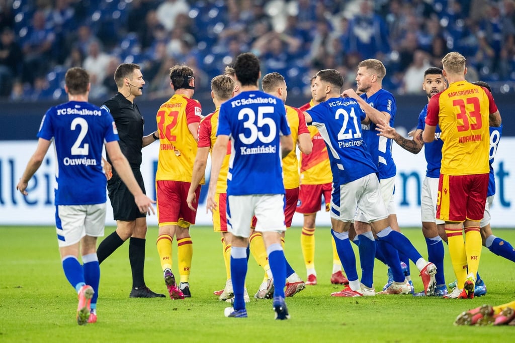 Zahlreiche Spieler diskutieren nach einer roten Karte für Schalkes Victor Palsson mit Schiedsrichter Christof Günsch (2.v.l).