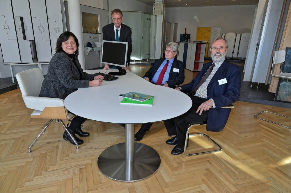 Am Schreibtisch, einem Produkt der Tamesis Design GmbH Platz genommen haben Tamesis-Geschäftsführerin Annet Loibl, Geschäftsführer Reinhard Frey, Oberbürgermeister Peter Kuras und Reinhard Flötotto (v.l.n.r.).