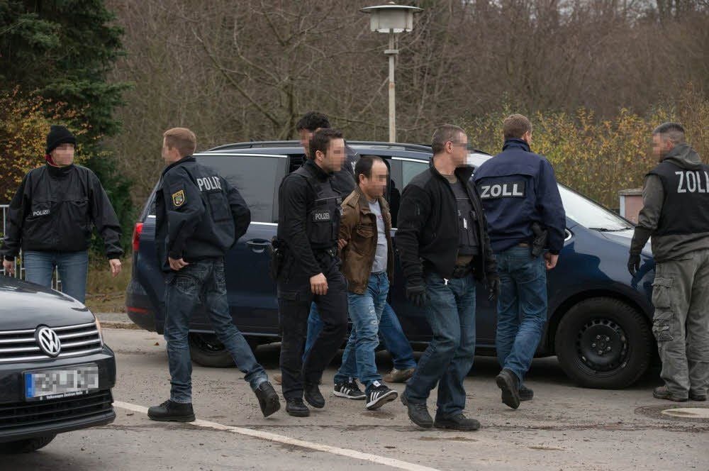 Der Verdächtige wird festgenommen, in ein Auto gebracht und abtransportiert.