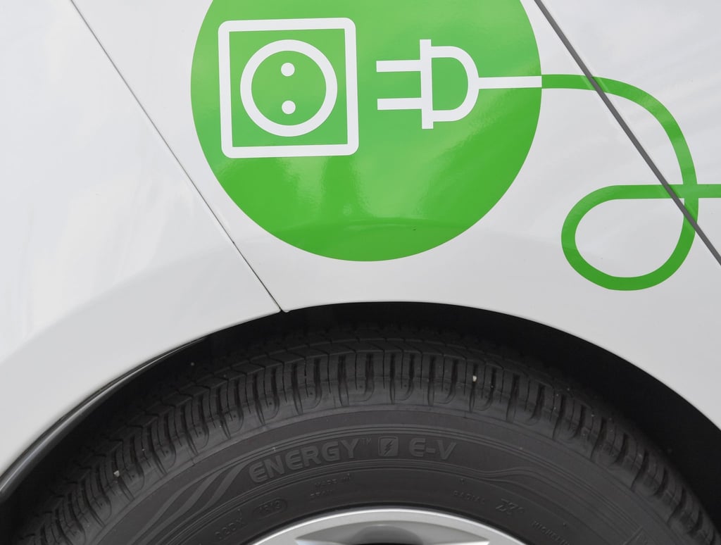 Ein Elektrofahrzeug wird an einer Stromtankstelle aufgeladen.