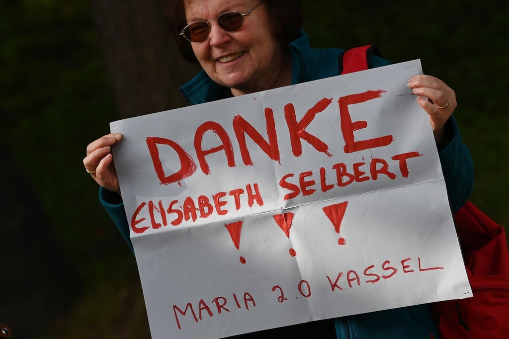 Eine Besucherin hält vor dem Festakt in der Hand.