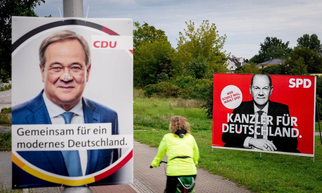 Eine Radfahrerin fährt in Adlershof an den Wahlplakaten vorbei.