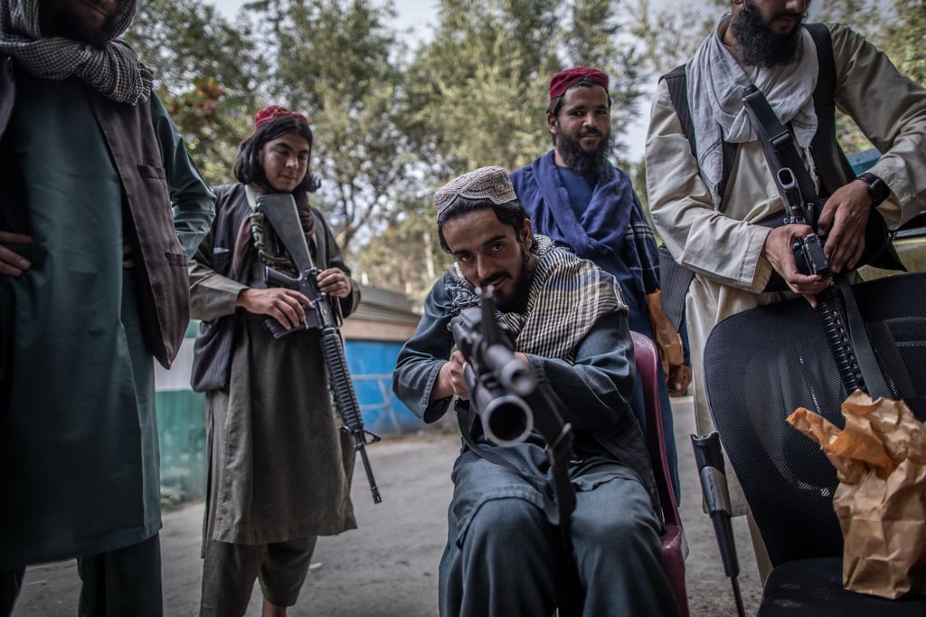 Ein junger Taliban-Kämpfer zielt zum Spaß mit seinem Gewehr in Richtung Fotograf, während er vor einer Polizeistation in Kabul Wache hält.