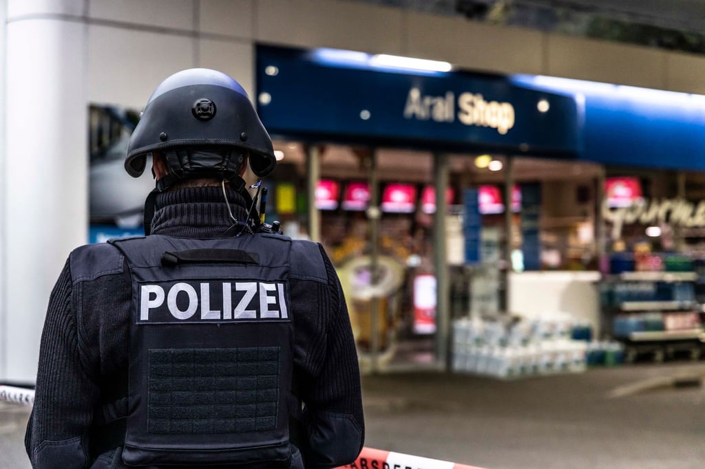 Ein Polizist sichert eine Tankstelle in Idar-Oberstein.
