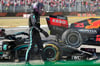 Lewis Hamilton vom Team Mercedes geht nach einem Zusammenstoß mit Red-Bull-Racing-Fahrer Verstappen an seinem Rennwagen vorbei.