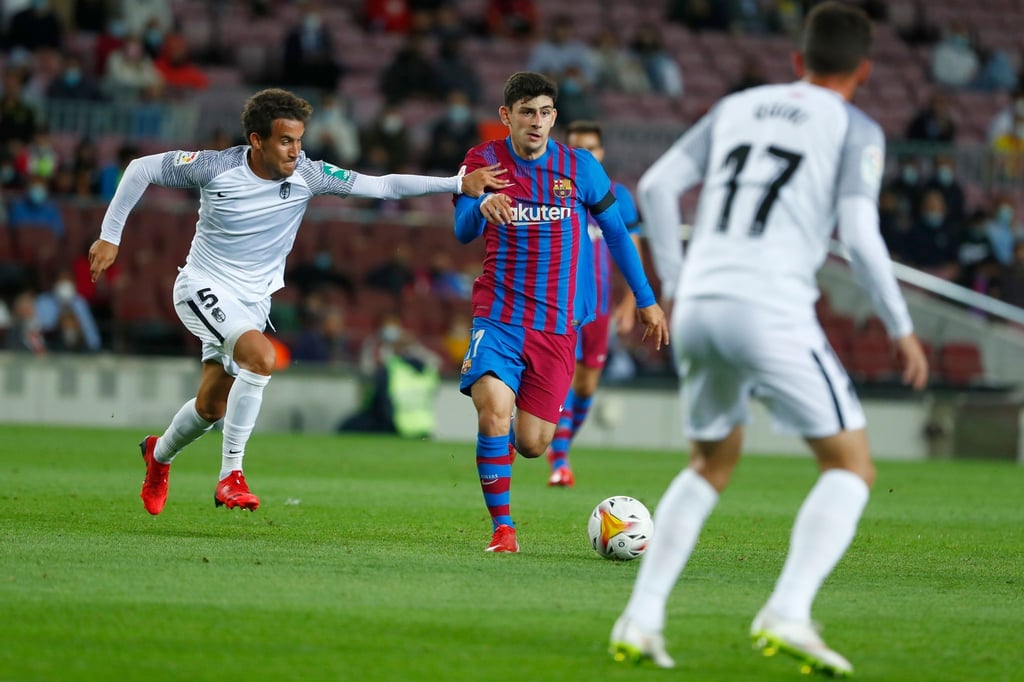 Luis Milla (l) vom FC Granada versucht Yusuf Demir (M) vom FC Barcelona zu stoppen.