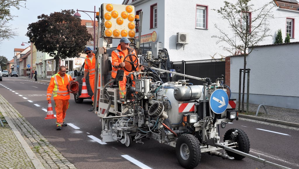 Georg Lasarsch, Marcus Ahlswede und der Kollege auf der Markiermaschine von der Firma Mark-Leit beim Markieren des Radweges auf der Genthiner Bahnhofstraße.