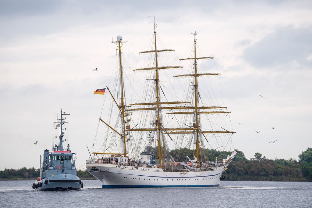 Die „Gorch Fock“ fährt, von einem Schlepper begleitet, aus dem Hafen.