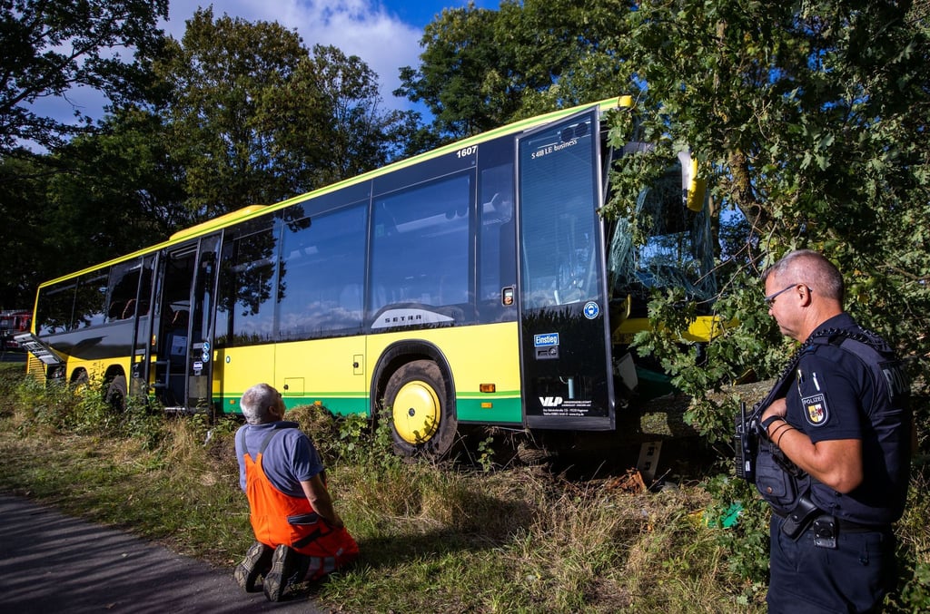 Einsatzkräfte sichern nach einem Busunfall mit mehreren verletzten Grundschülern die Unglücksstelle.
