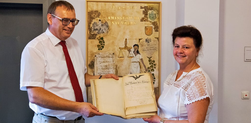 Angelika Kunze mit Amtsgerichtsdirektor Andreas Sander vor dem Bild, zu dem sie von der davor gezeigten alten Personalakte inspiriert wurde.
