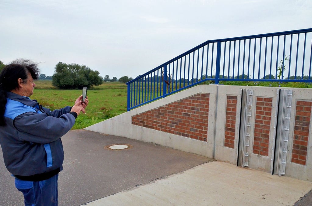 Peter Damker, Stadtrat und Leiter der Sandauer Wasserwehr, fotografiert die angebauten Führungsschienen. Das ist beim späteren Wiederaufbau hilfreich.