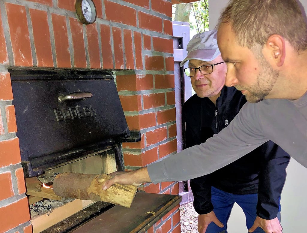 Ofenbaumeister Frank Döring aus Schönhausen heizt den neuen Backofen das erste Mal an. Klaus-Dieter Siegel sieht ihm zu, damit später jeder Handgriff sitzt. Übrigens: den Vorgänger des Ofens hatte Frank Dörings Vater, der auch Frank heißt, Mitte der 90-er Jahre gebaut.